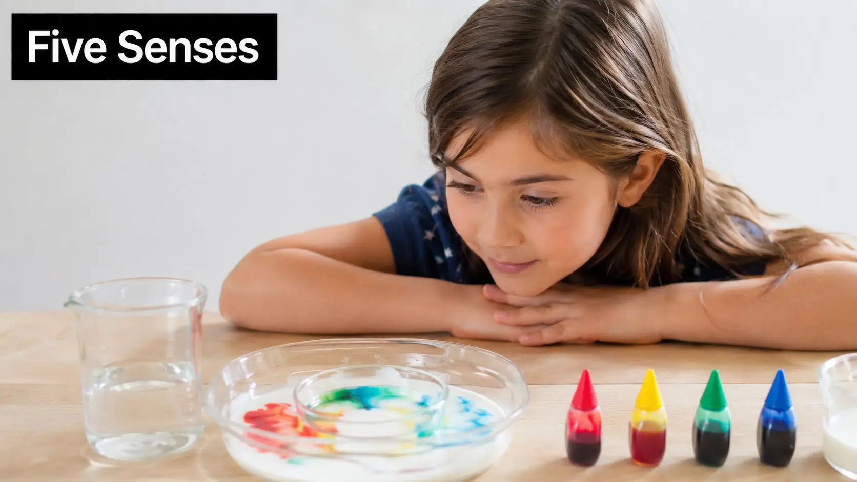 A young girl observing a colorful science experiment with milk and food coloring in a bowl.