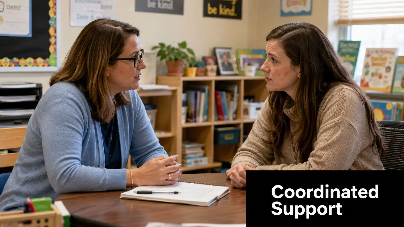 A teacher and a parent are having a conversation during a school meeting in a classroom.