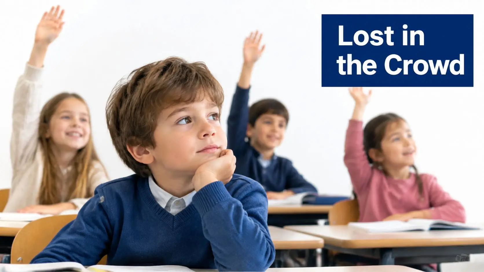 A group of young students sitting at desks in a classroom with their hands raised to answer.