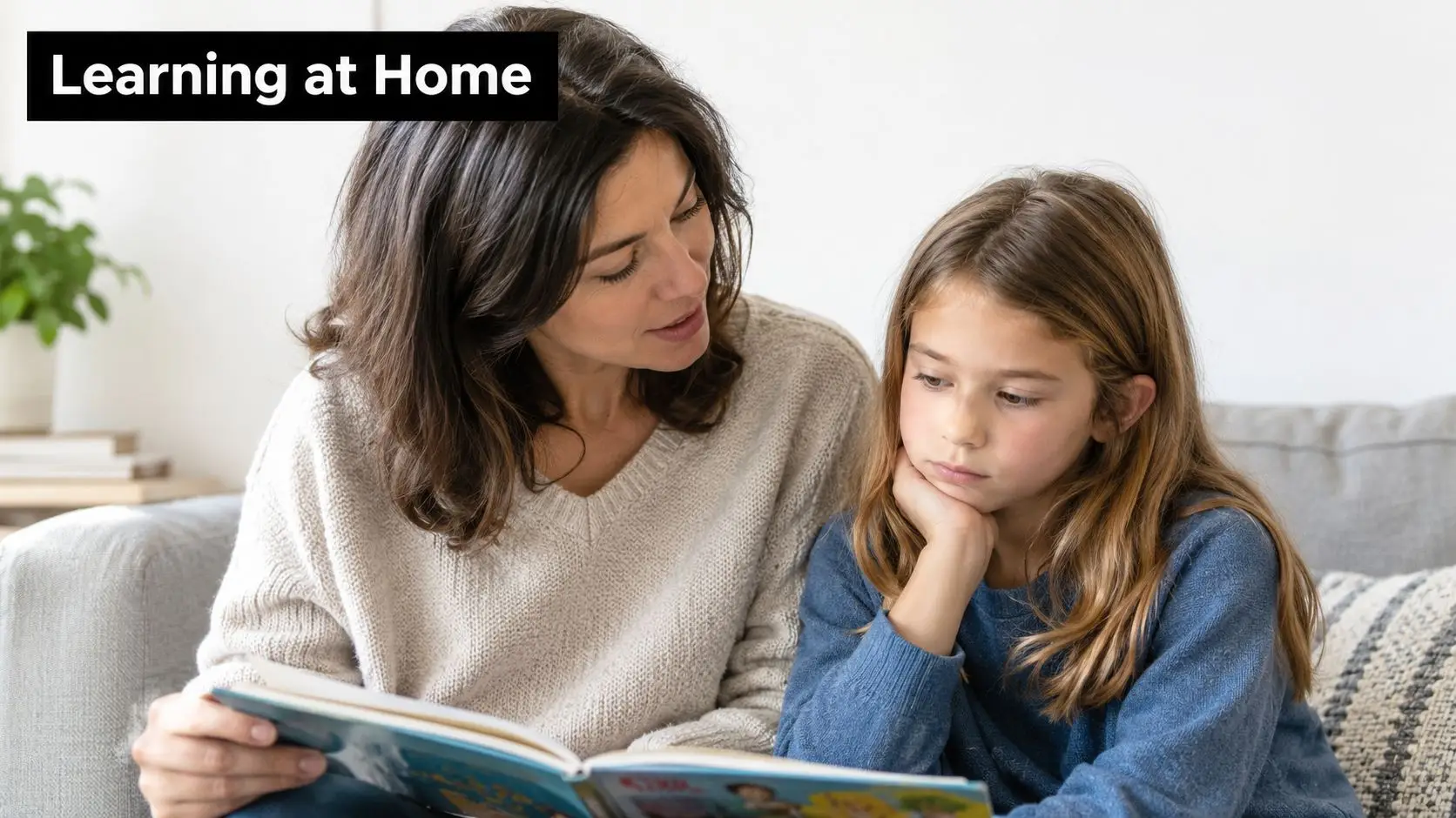 A caring mother reading a storybook to her young daughter while sitting together on a couch.